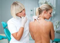 Ärztin untersucht Rücken einer Frau