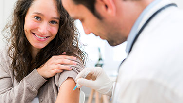 Mädchen erhält Impfung von Arzt